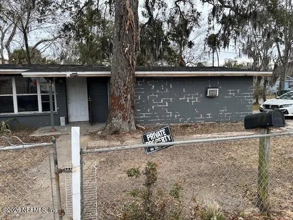 a front view of a house with a tree