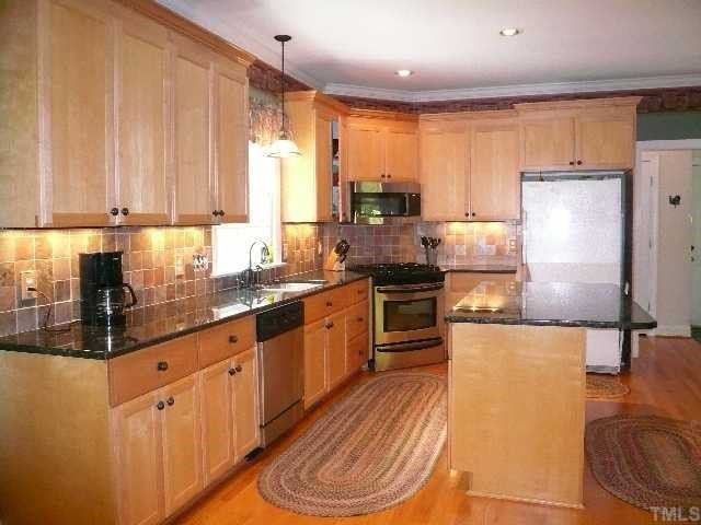 5908 Orchid Valley Road Raleigh, NC 27613 - Photo 3 of 12 This home offers a huge kitchen with center isle w/ breakfast bar, gorgeous granite countertops, new stainless steel gas range, new stainless steel microwave, new stainless steel dishwasher, tile backsplash, pantry, custom cabinetry and recessed lighting. Kitchen