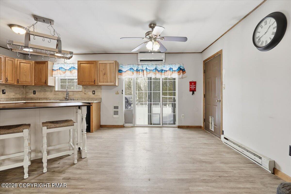 199 Magic Mountain Road Henryville, PA 18332 - Photo 11 of 74 a open kitchen with granite countertop a stove a sink dishwasher a dining table and chairs with wooden floor