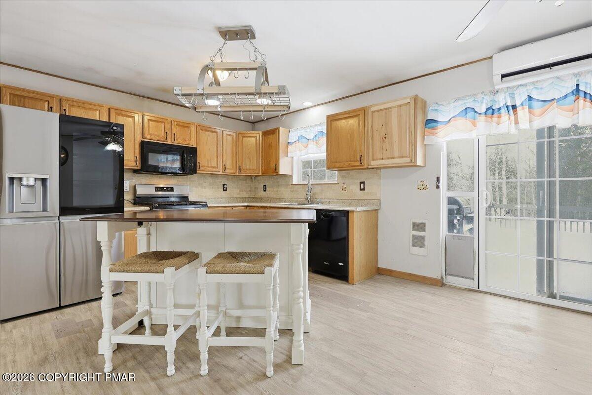 199 Magic Mountain Road Henryville, PA 18332 - Photo 14 of 74 a kitchen with stainless steel appliances granite countertop a table chairs refrigerator and microwave