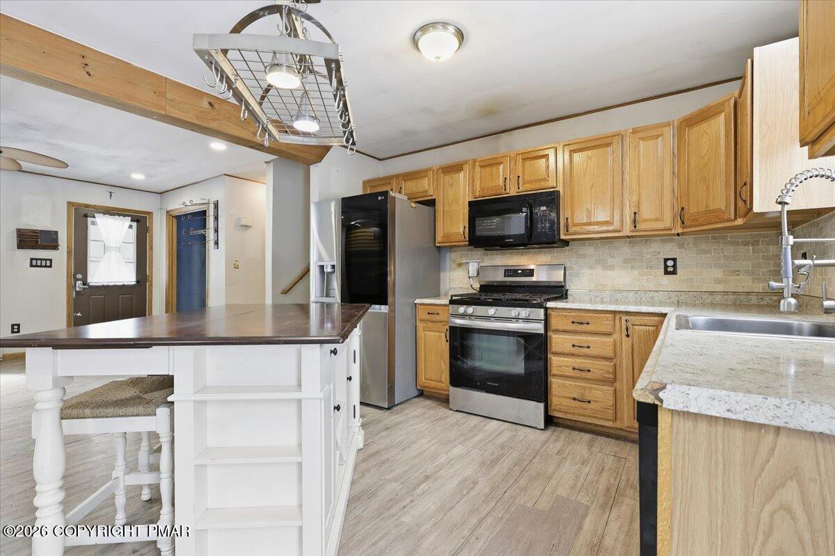 199 Magic Mountain Road Henryville, PA 18332 - Photo 16 of 74 a kitchen with stainless steel appliances granite countertop a stove top oven a sink dishwasher a dining table and chairs with wooden floor