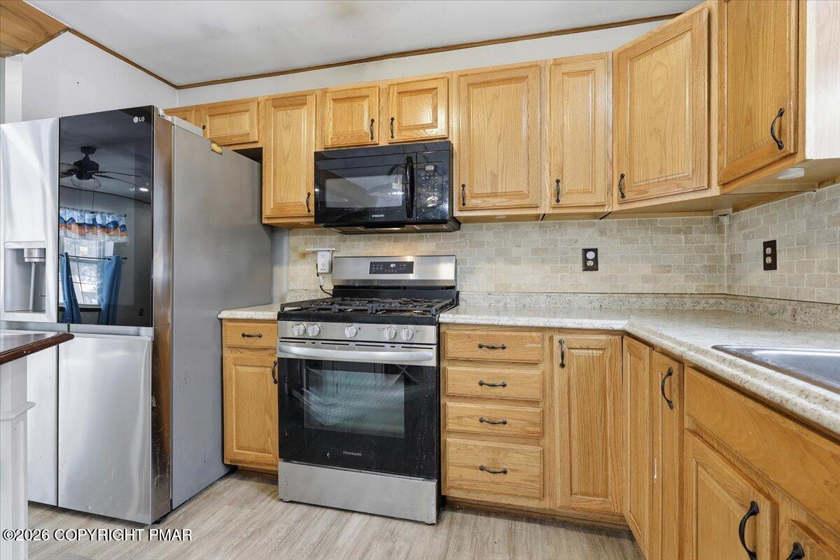 199 Magic Mountain Road Henryville, PA 18332 - Photo 19 of 74 a kitchen with stainless steel appliances granite countertop a stove a sink and a microwave