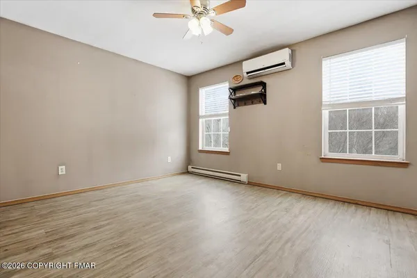 an empty room with wooden floor and windows