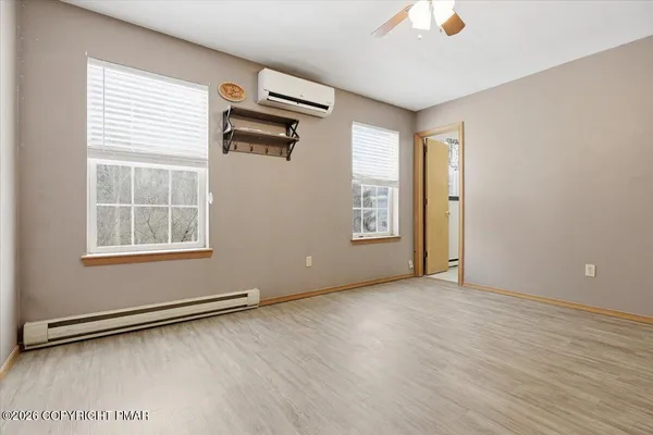 an empty room with wooden floor and a window