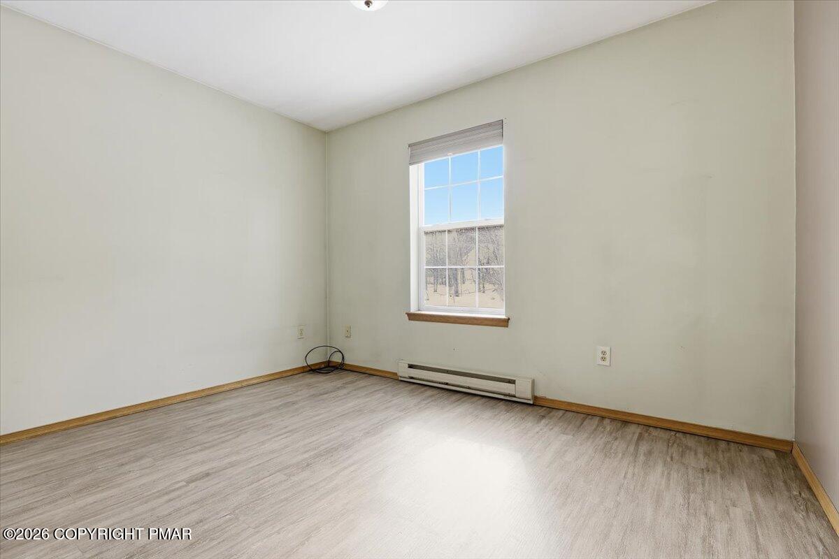 199 Magic Mountain Road Henryville, PA 18332 - Photo 32 of 74 an empty room with wooden floor and windows