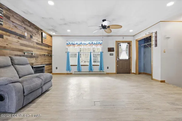 a open kitchen with granite countertop a stove a sink dishwasher a dining table and chairs with wooden floor