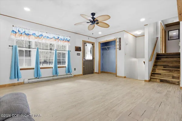 a view of kitchen with stainless steel appliances wooden floor and chair