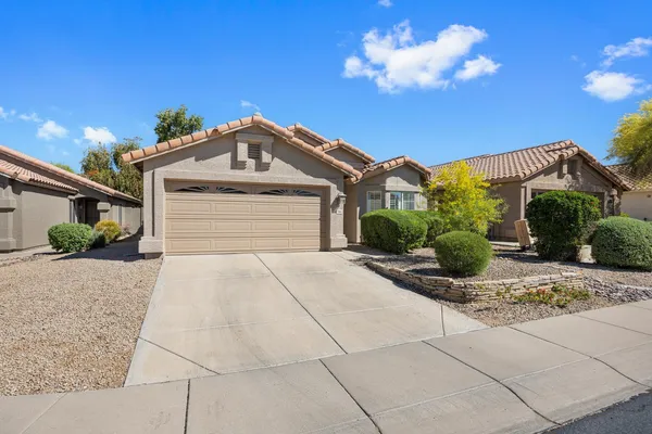 a front view of a house with a yard and a garage