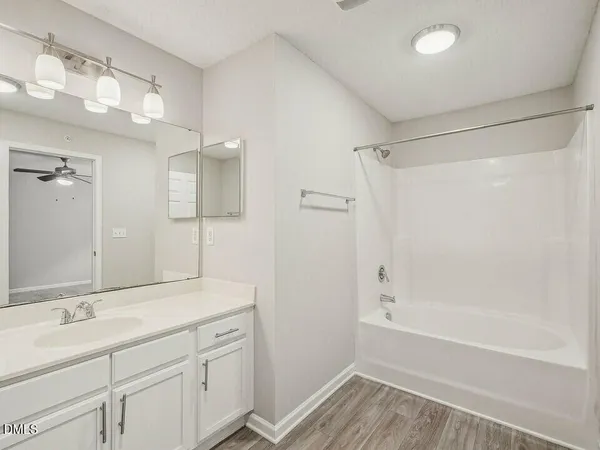 a bathroom with a shower sink and mirror