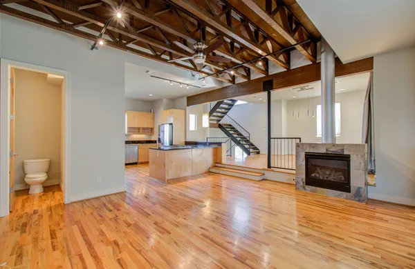 a view of a livingroom with wooden floor and stairs