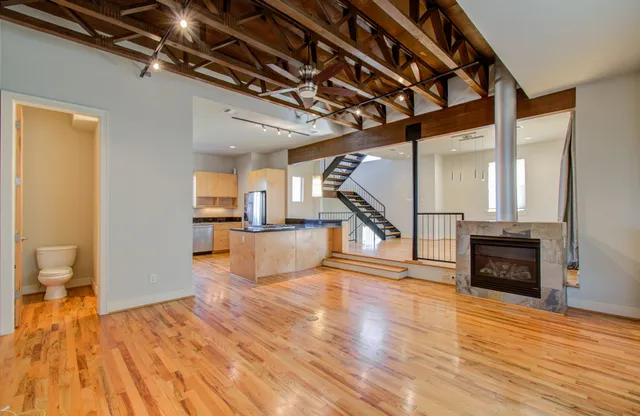 a view of a livingroom with wooden floor and stairs