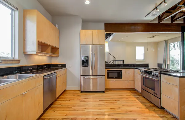 a kitchen with stainless steel appliances granite countertop a stove a sink and a refrigerator