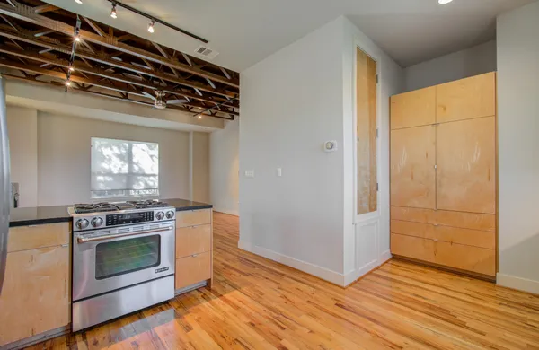 a kitchen with granite countertop a stove and a wooden floor