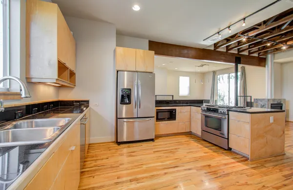 a kitchen with granite countertop a refrigerator and a stove top oven