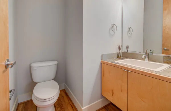 a bathroom with a toilet sink and mirror