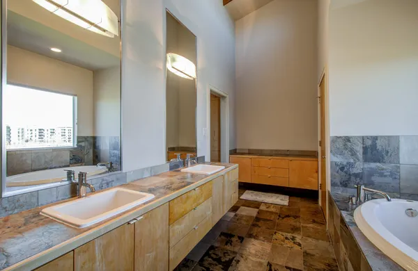 a bathroom with a granite countertop tub sink and shower