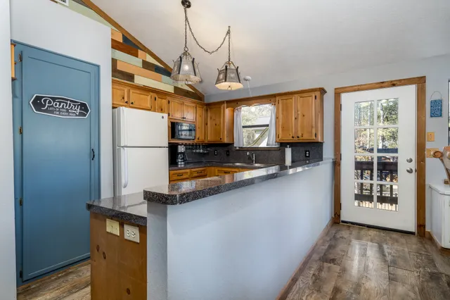 a kitchen with stainless steel appliances granite countertop a refrigerator a oven and a sink with granite countertops