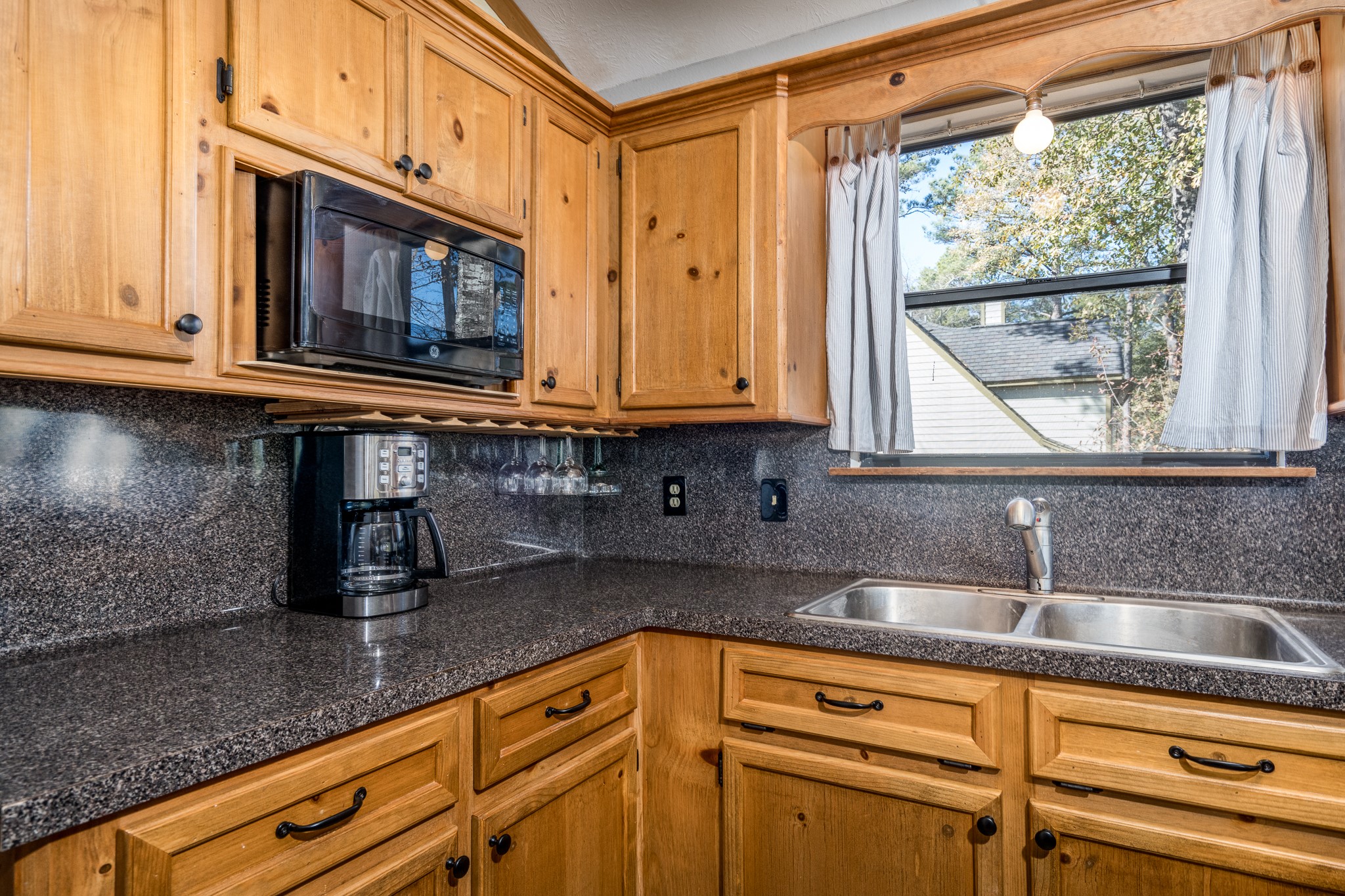 97 Greenway Drive Trinity, TX 75862 - Photo 21 of 49 a kitchen with granite countertop a sink a microwave cabinets and stainless steel appliances