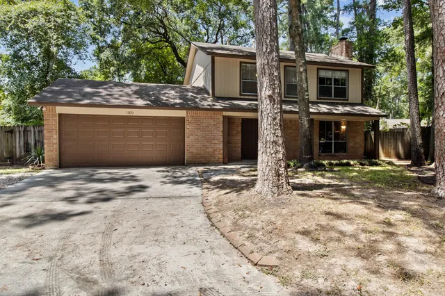 a view of a house with backyard and trees