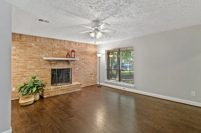 an empty room with windows and fireplace