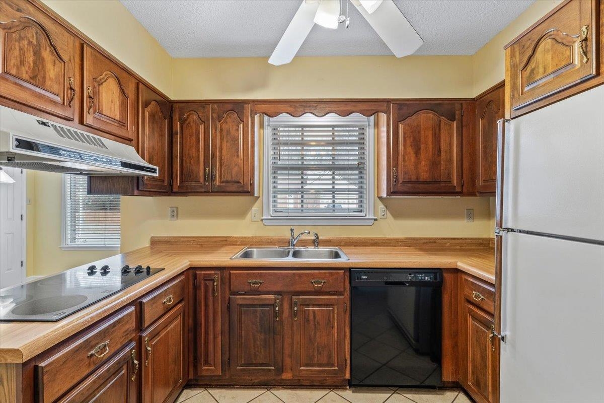 2587 McVay Road Memphis, TN 38119 - Photo 12 of 35 Kitchen featuring black appliances, light countertops, plenty of natural light, light tile patterned flooring, and a textured ceiling