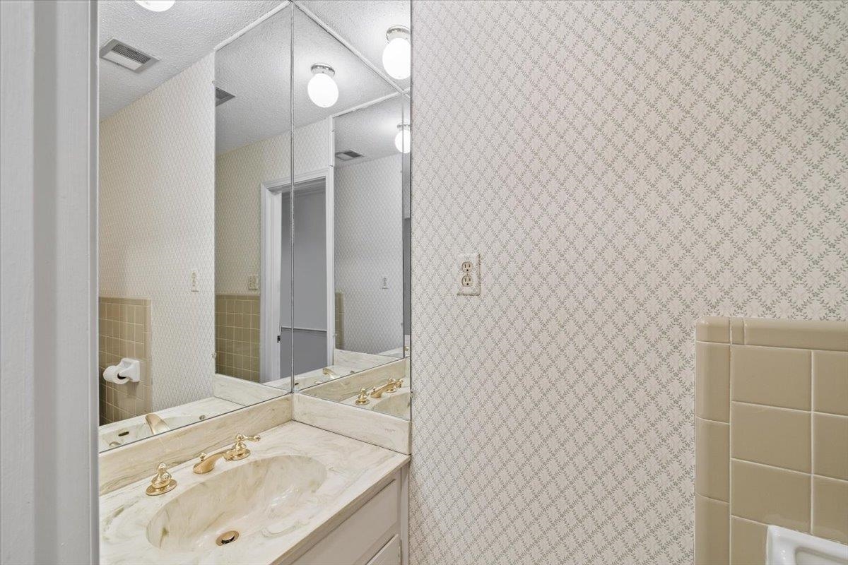 2587 McVay Road Memphis, TN 38119 - Photo 18 of 35 Hall 1/2 Bathroom featuring wallpapered walls and vanity