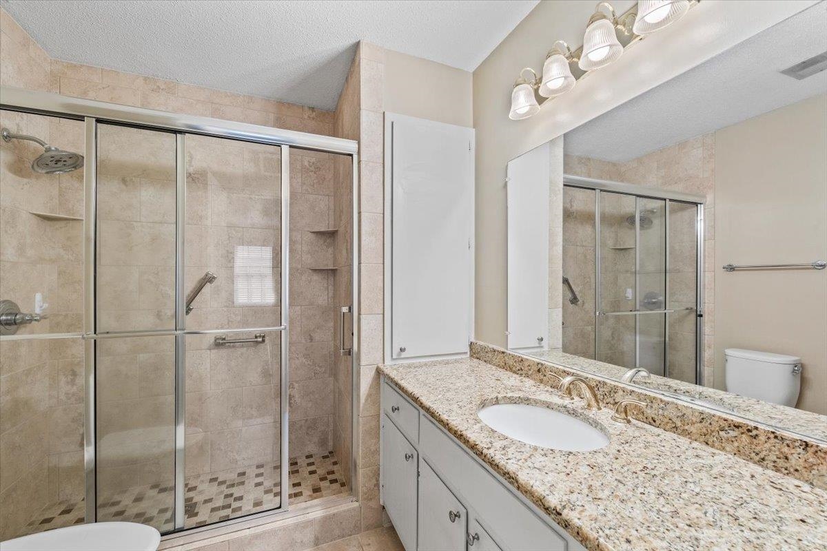 2587 McVay Road Memphis, TN 38119 - Photo 20 of 35 Bathroom with vanity, a shower stall, and a textured ceiling