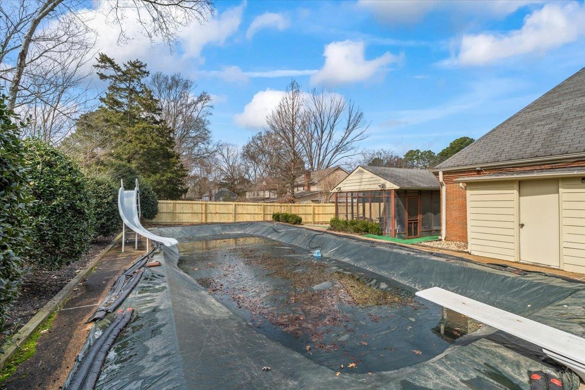 2587 McVay Road Memphis, TN 38119 - Photo 29 of 35 View of swimming pool with a water slide, a diving board, a fenced backyard, and a sunroom