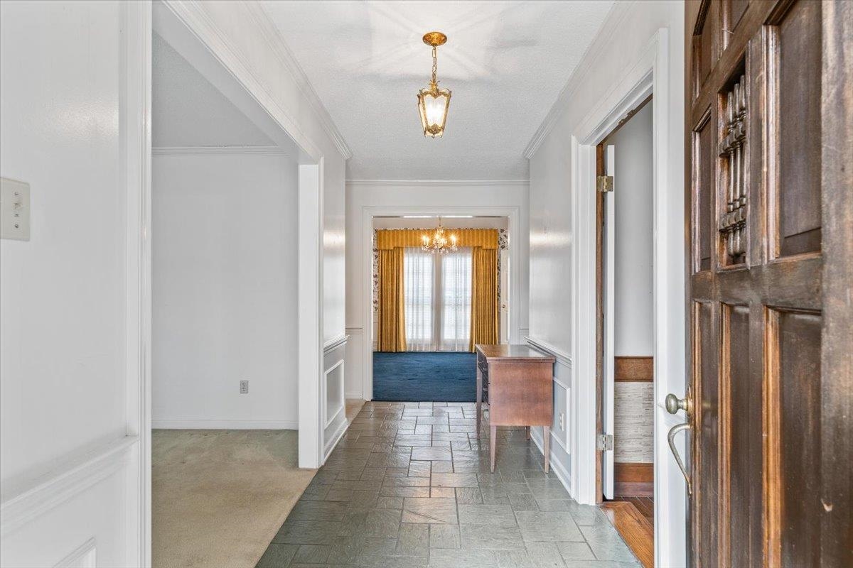 2587 McVay Road Memphis, TN 38119 - Photo 5 of 35 Foyer with stone tile flooring, hanging lights, light colored carpet, crown molding, and a wainscoted wall