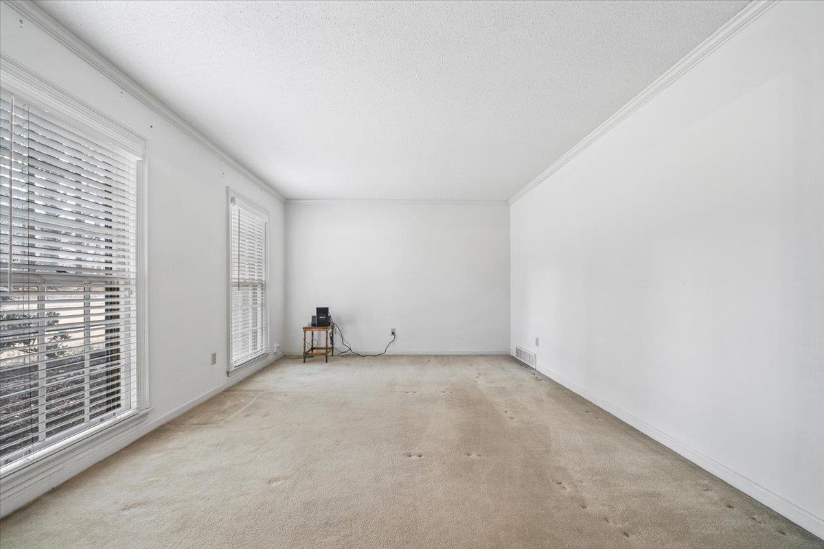 2587 McVay Road Memphis, TN 38119 - Photo 6 of 35 Carpeted spare room featuring a textured ceiling and crown molding