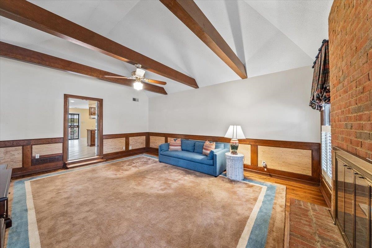 2587 McVay Road Memphis, TN 38119 - Photo 9 of 35 Unfurnished living room with wainscoting, lofted ceiling with beams, a ceiling fan, and wood finished floors