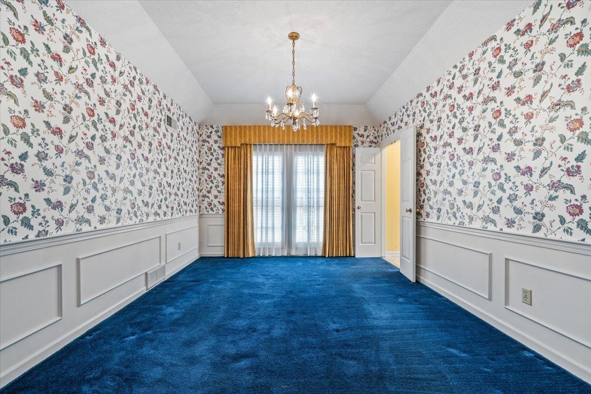 2587 McVay Road Memphis, TN 38119 - Photo 10 of 35 Unfurnished dining area with a chandelier, wallpapered walls, lofted ceiling, wainscoting, and a decorative wall