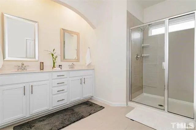 a bathroom with a shower sink and mirror