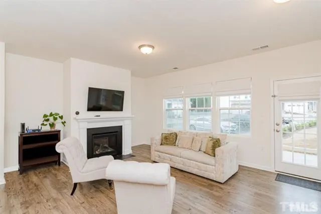 a living room with furniture a flat screen tv and a fireplace