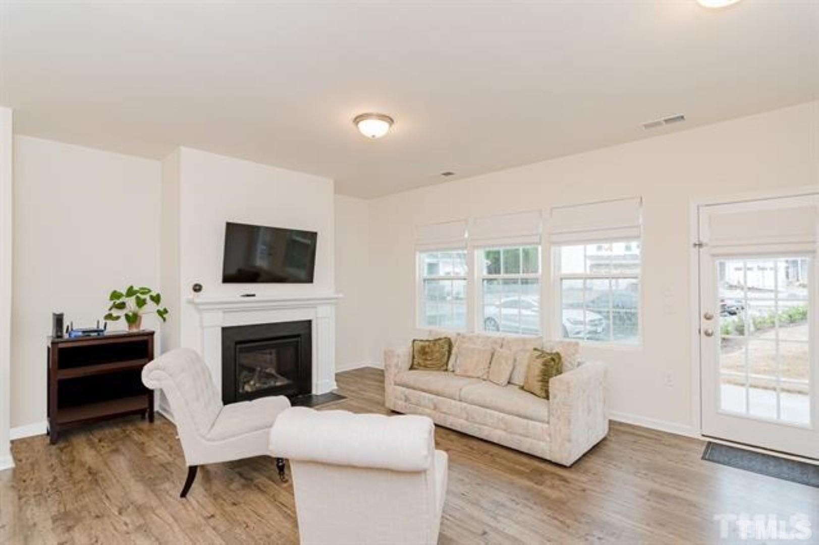 1118 Epiphany Road Morrisville, NC 27560 - Photo 5 of 20 a living room with furniture a flat screen tv and a fireplace