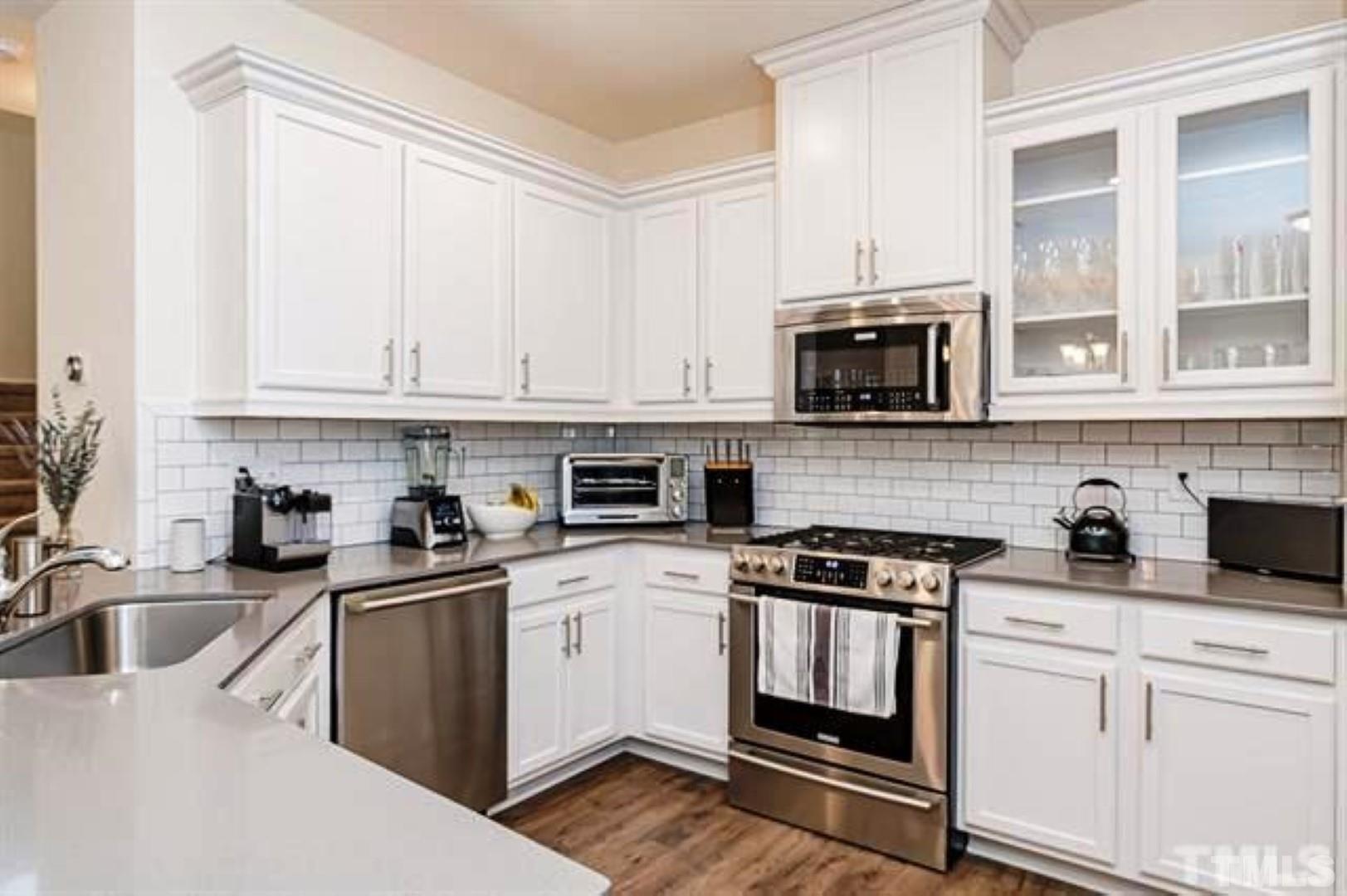 1118 Epiphany Road Morrisville, NC 27560 - Photo 8 of 20 a kitchen with granite countertop a sink a stove and microwave