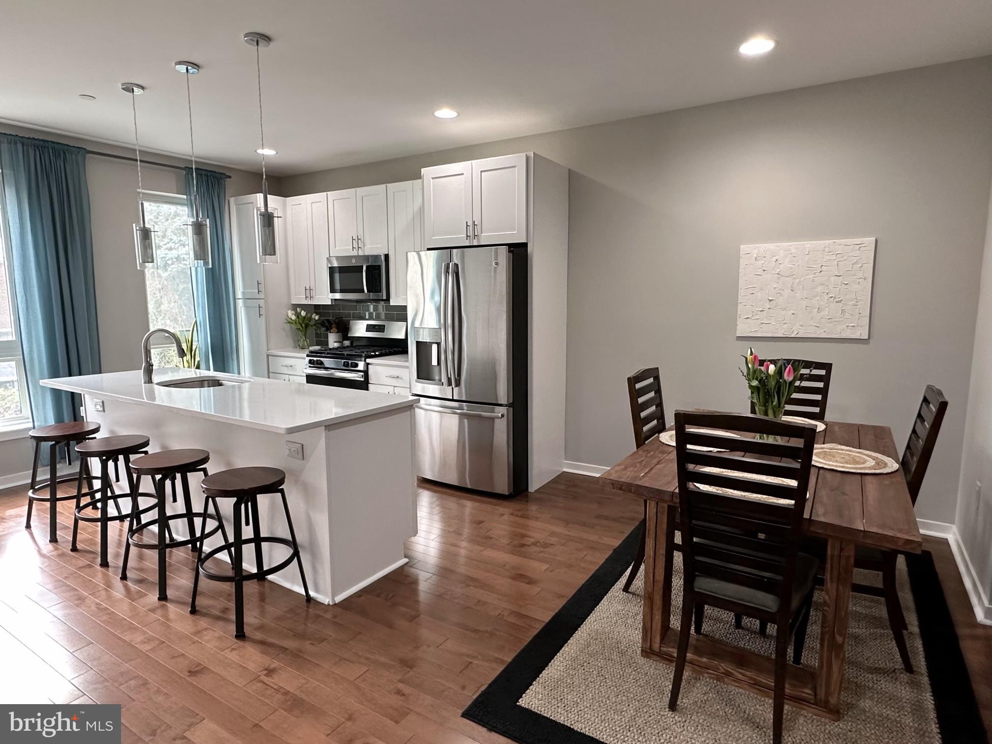 a kitchen with kitchen island a wooden floor and chairs