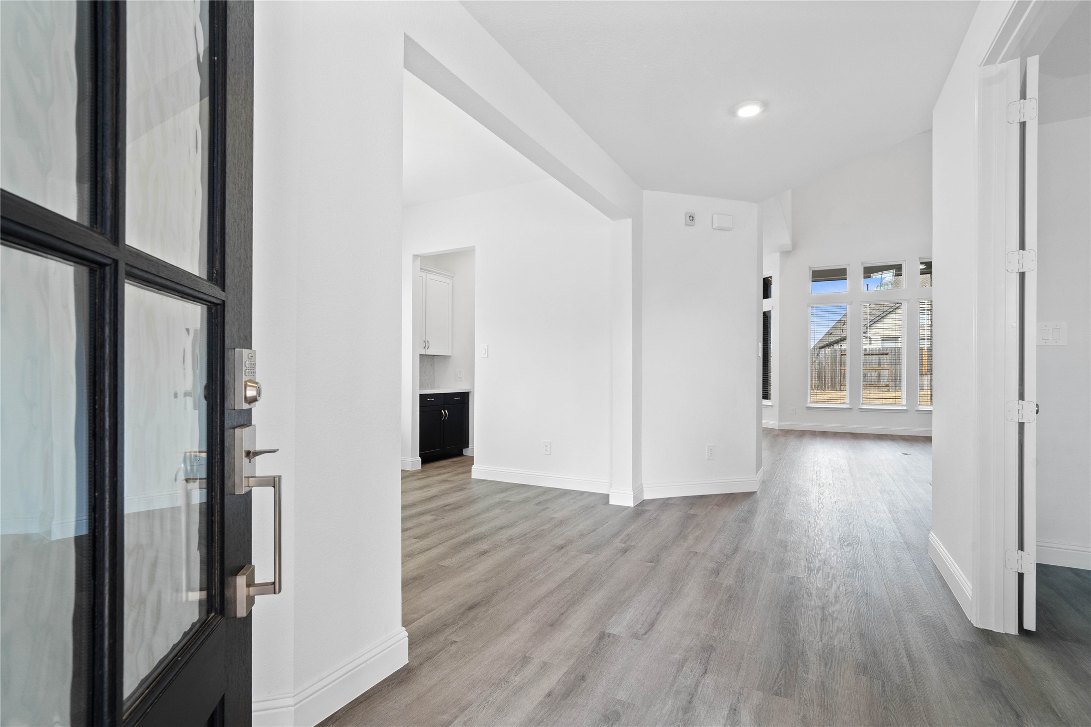 17315 July Moon Lane Conroe, TX 77302 - Photo 6 of 46 An inviting entrance opens up to an open-concept layout, seamlessly connecting the entry to the living areas with durable luxury vinyl plank flooring and striking architectural details.