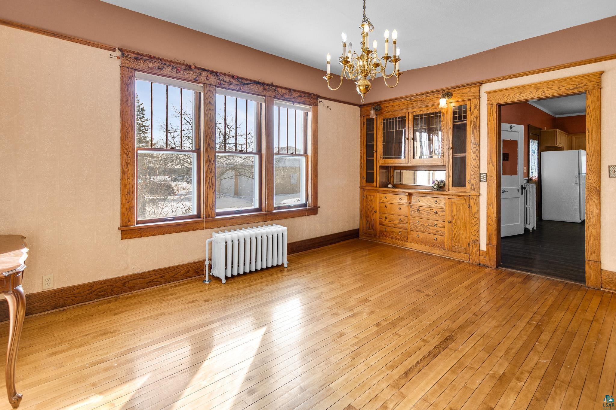 6494 School Street Finlayson, MN 55735 - Photo 6 of 31 Unfurnished dining area featuring radiator heating unit, hanging lights, and light wood finished floors