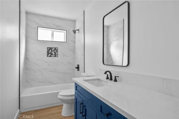 a bathroom with a granite countertop sink a toilet and a bathtub