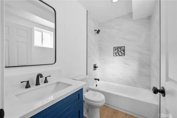 a bathroom with a sink vanity mirror and toilet