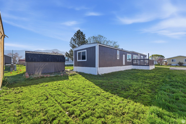 2491 Highway 89, Unit 523 Pleasant View, UT 84404 - Photo 21 of 31 View of home's exterior with a yard and a storage unit