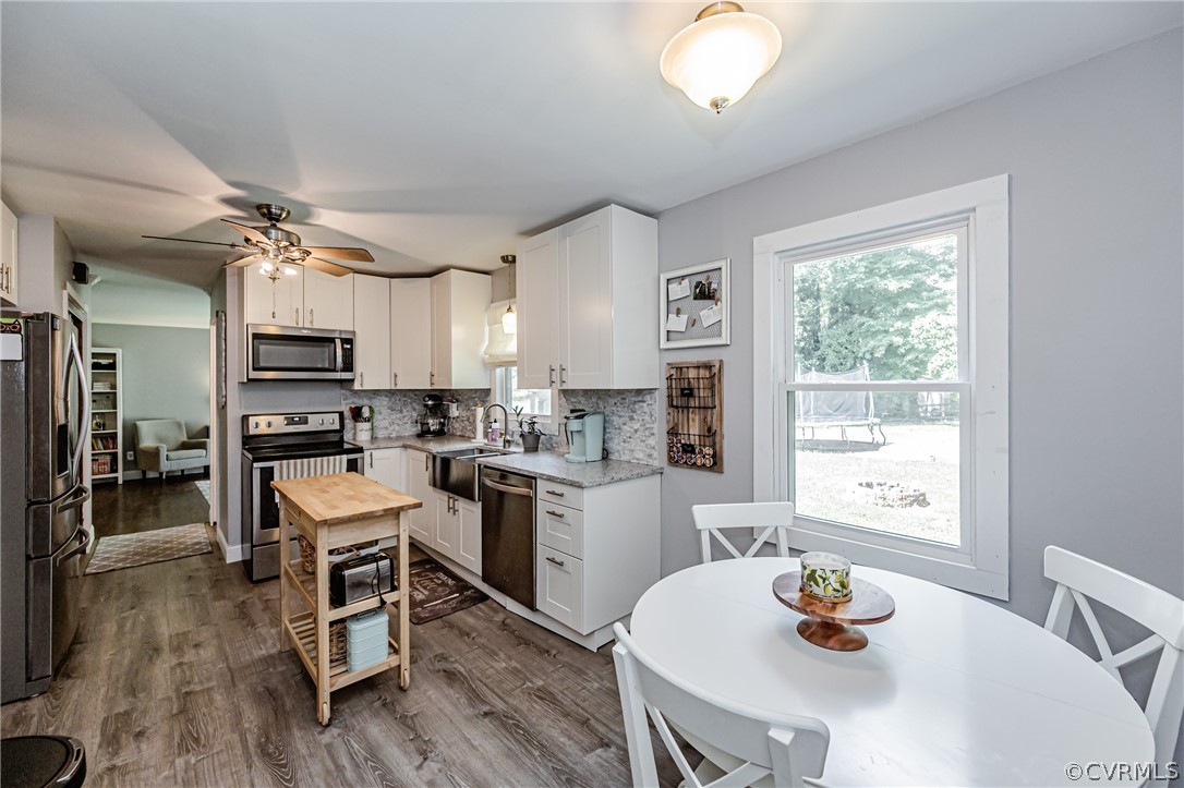 5018 Rollingway Road Chesterfield, VA 23832 - Photo 19 of 49 a kitchen with a table chairs a stove a dining table and chairs