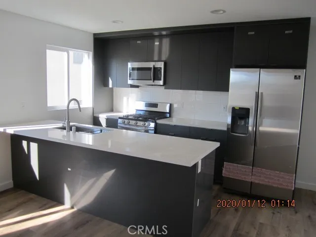 a kitchen with a sink a refrigerator and trees