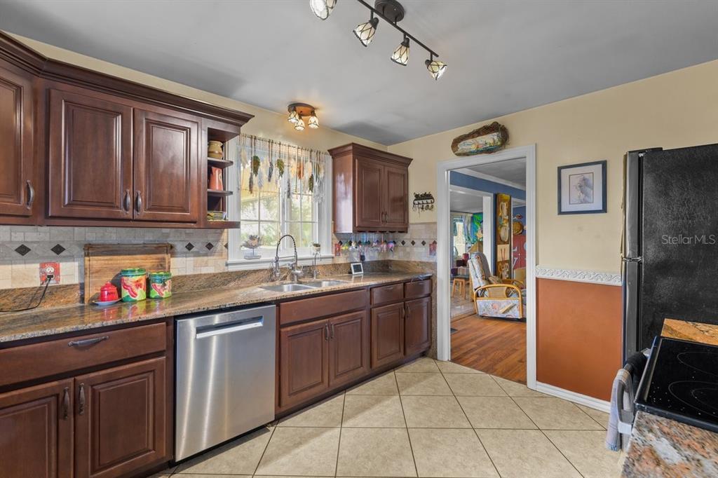 101 Orange Street Satsuma, FL 32189 - Photo 11 of 65 a kitchen with granite countertop a sink dishwasher stove and cabinets