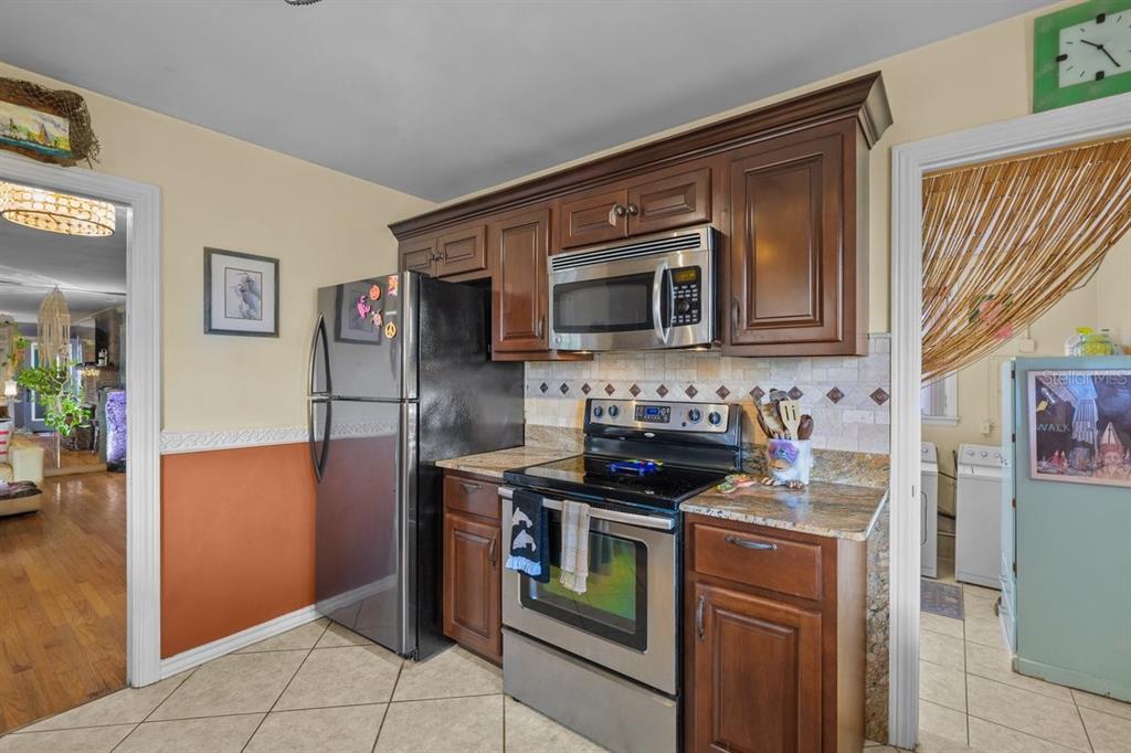 101 Orange Street Satsuma, FL 32189 - Photo 12 of 65 a kitchen with stainless steel appliances granite countertop a stove microwave and refrigerator