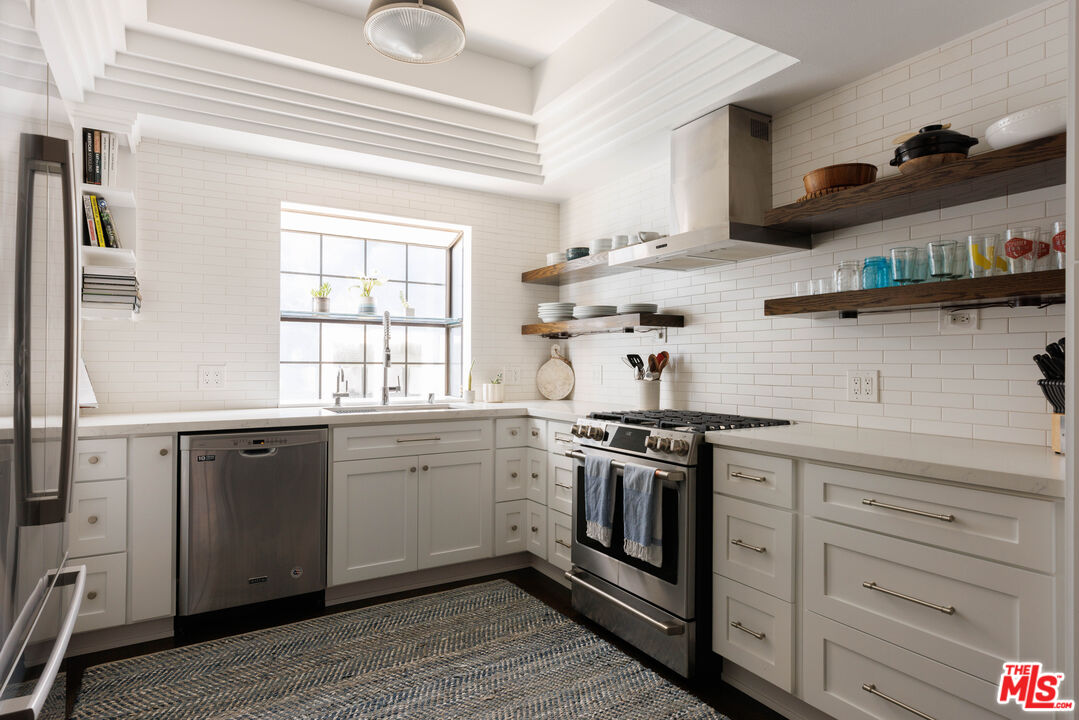 36 Navy Street, Unit 4 Venice, CA 90291 - Photo 9 of 37 a kitchen with stainless steel appliances granite countertop a stove and white cabinets