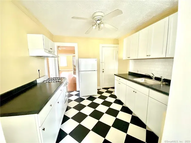 a kitchen with a refrigerator a sink and a window