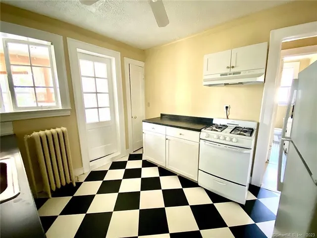 a kitchen with a checkered floor and white cabinets