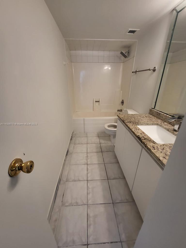 13499 Biscayne Boulevard, Unit 1204 North Miami, FL 33181 - Photo 11 of 14 a bathroom with a granite countertop sink a toilet and a mirror